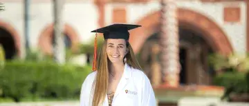 Carly Shaw in lab coat posed in Ponce courtyard
