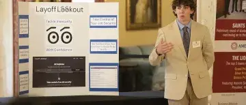 Student standing next to a business presentation