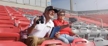 Jim Gilmore and Tracy Halcomb sitting in the bleachers at Drysdale field