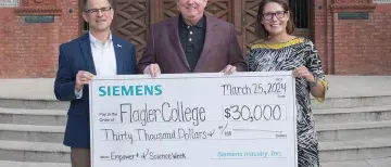 Steve Hoiberg, President Delany, and Laura Stevenson hold a large check from Siemens for $30,000