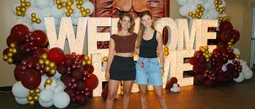 Students posing in front of Welcome Home sign
