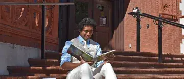 Chris Lowery in front of library reading book