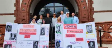 Students with final poster presentations posed in front of Proctor