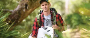 Professor Sam McMillan holding a surfboard