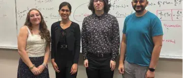 Christina Marks and others in front of white board with Math on it