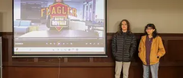 Two students stand at the front of class ready to present their film.