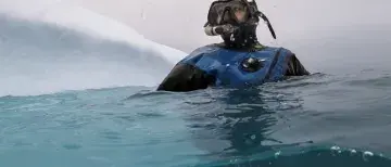 Claire Mortensen floating in the Arctic Sea in full scuba diving gear