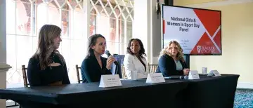 The four panel speakers sit at the front of the room for National Women and Girls in Sport Day