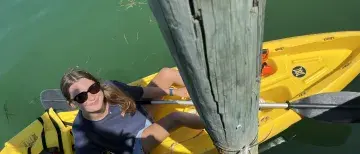 Zoe Kieffer sits in a kayak on the water while conducting her research