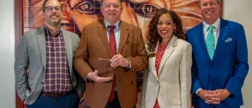 President John Delaney, Vice President & Chief Human Resources Officer Kelly Toaston, Compensation and Benefits Campus Partner Hayden George, and Trustee Mark Bailey Sr pose with the wellness award