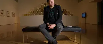 CEAM Artist Ballengee - Man sitting on a bench in an art gallery