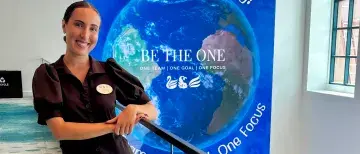 Addison Da Silva stands in front of a banner at the Swan and Dolphin resort