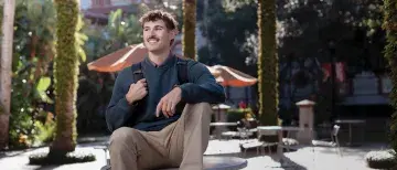 Environmental Science student Pasquale Arnone smiling and sitting on a table