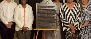 Dr. Michael Butler and Members of the Black Student Union stand with the commemorative plaque