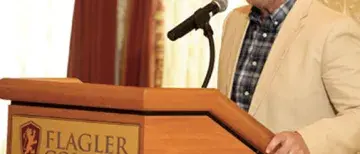 Flagler-Parents-weekend-505x505.jpg Art Vanden Houten standing at the podium in the Flagler Room