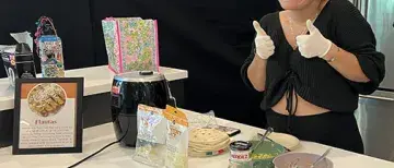 505x505 LASO event.jpeg Student at LASO cooking event smiles and gives thumbs up while presenting dish