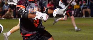 Lacrosse athlete, Ty Tom, on the field at inaugural lacrosse game. 