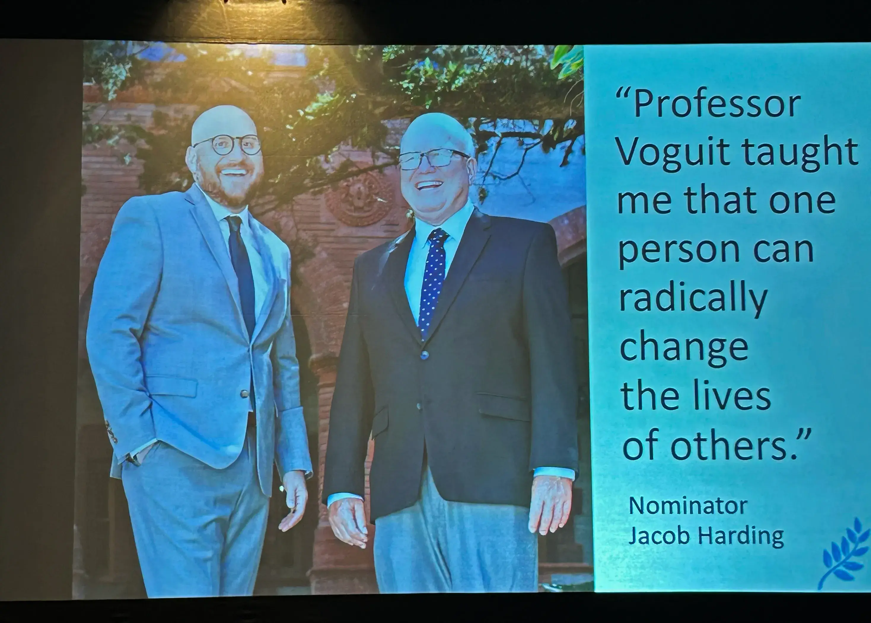 Voguit and Harding shown on a slide with the quote, Professor Voguit taught me that one person can radically change the lives of others.