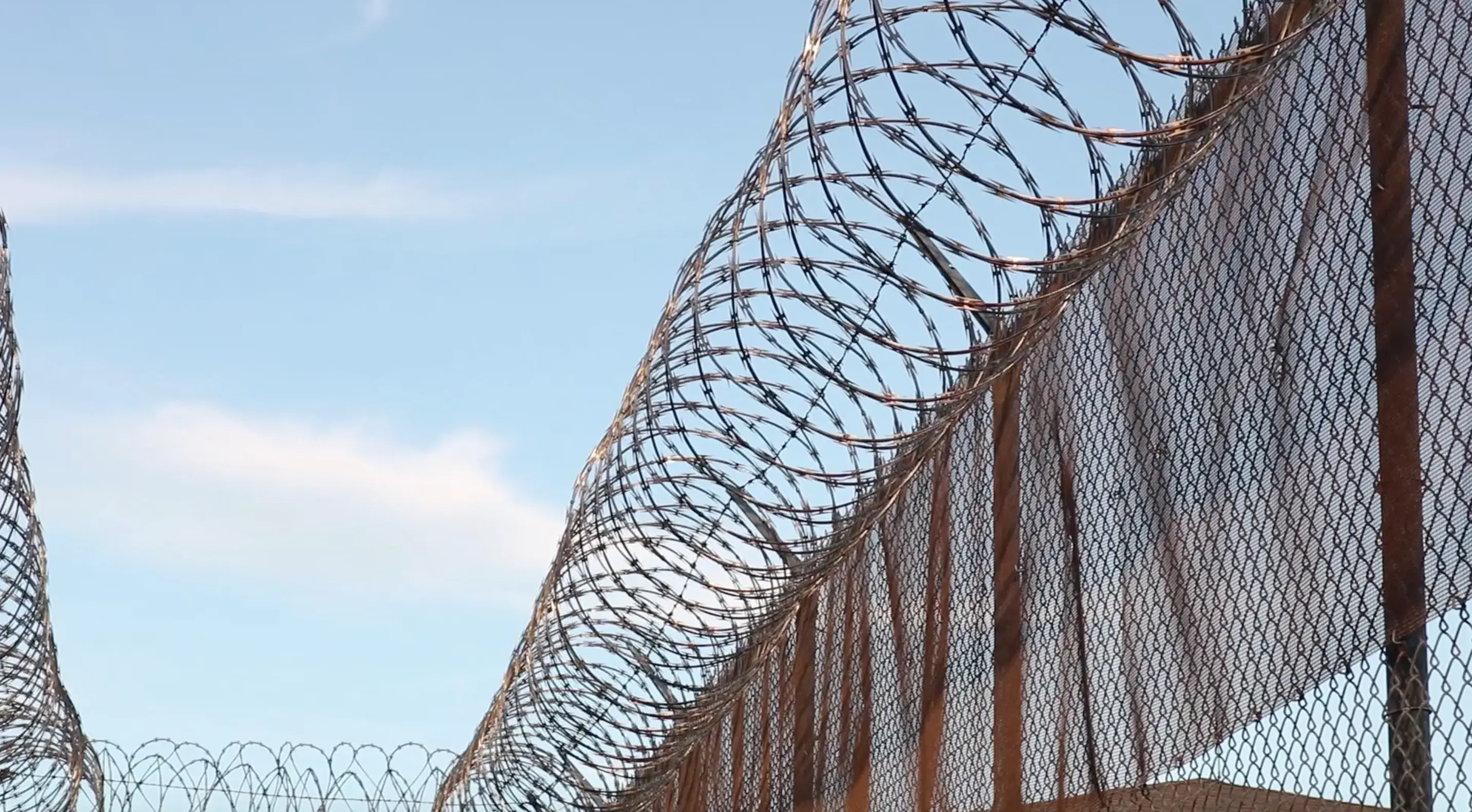 A large fence with razor wire across the top