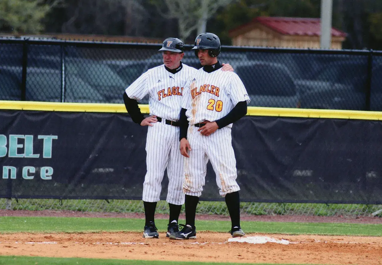 Older photo of Coach Barnett coaching a student during a baseball game