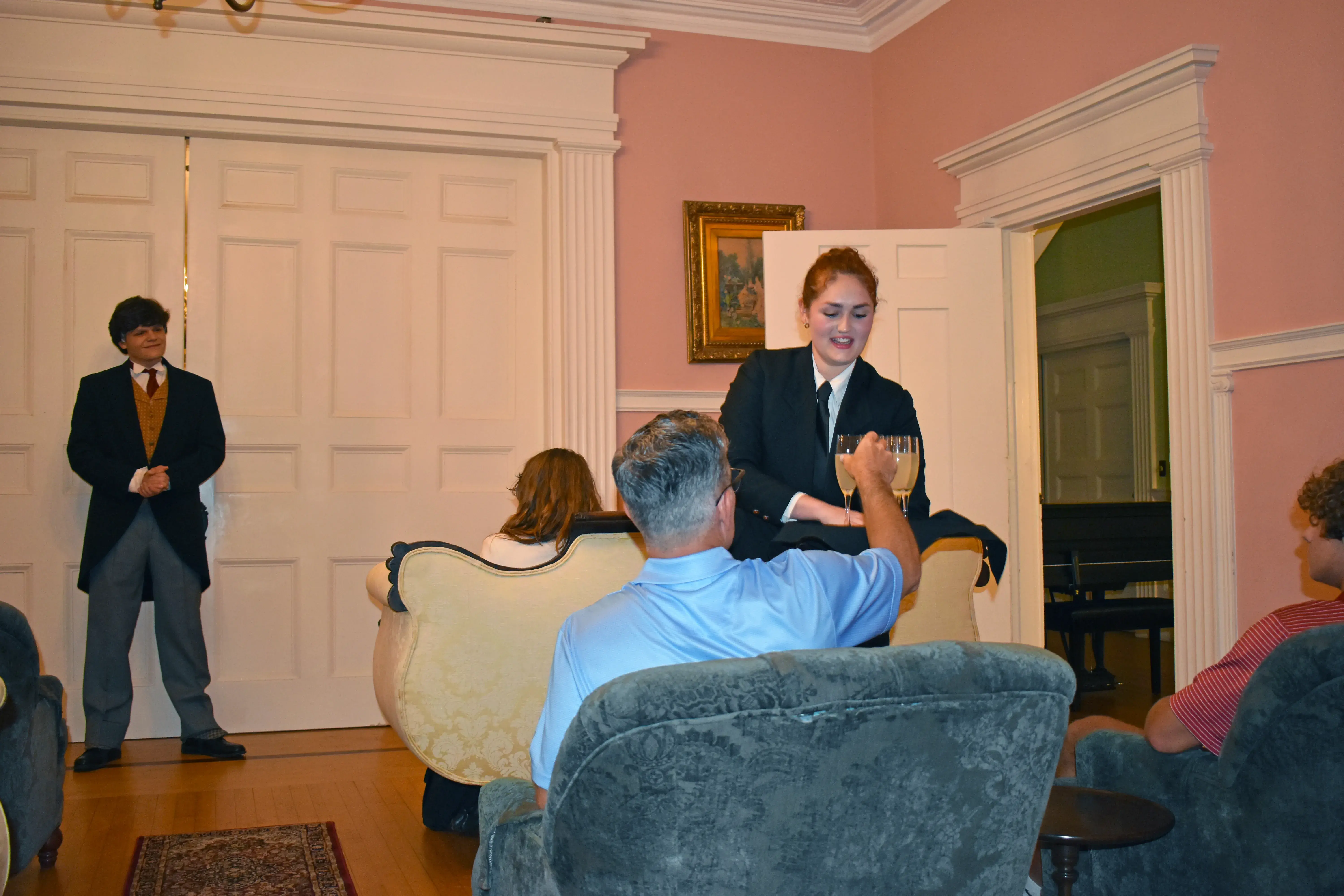 Character serves cocktails to guests in Pink Room