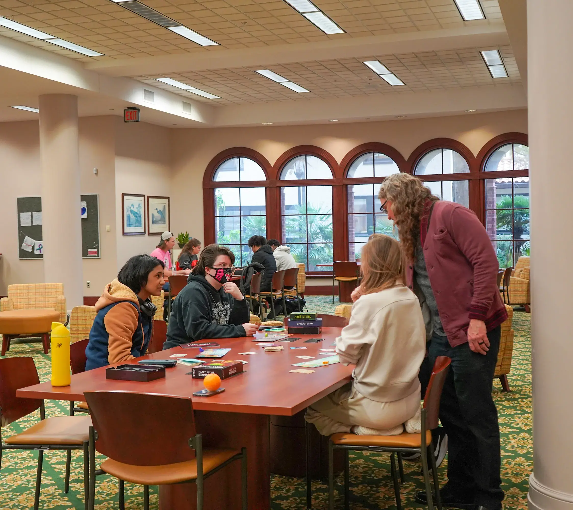 Moody stands by table of students playing game, offers insight