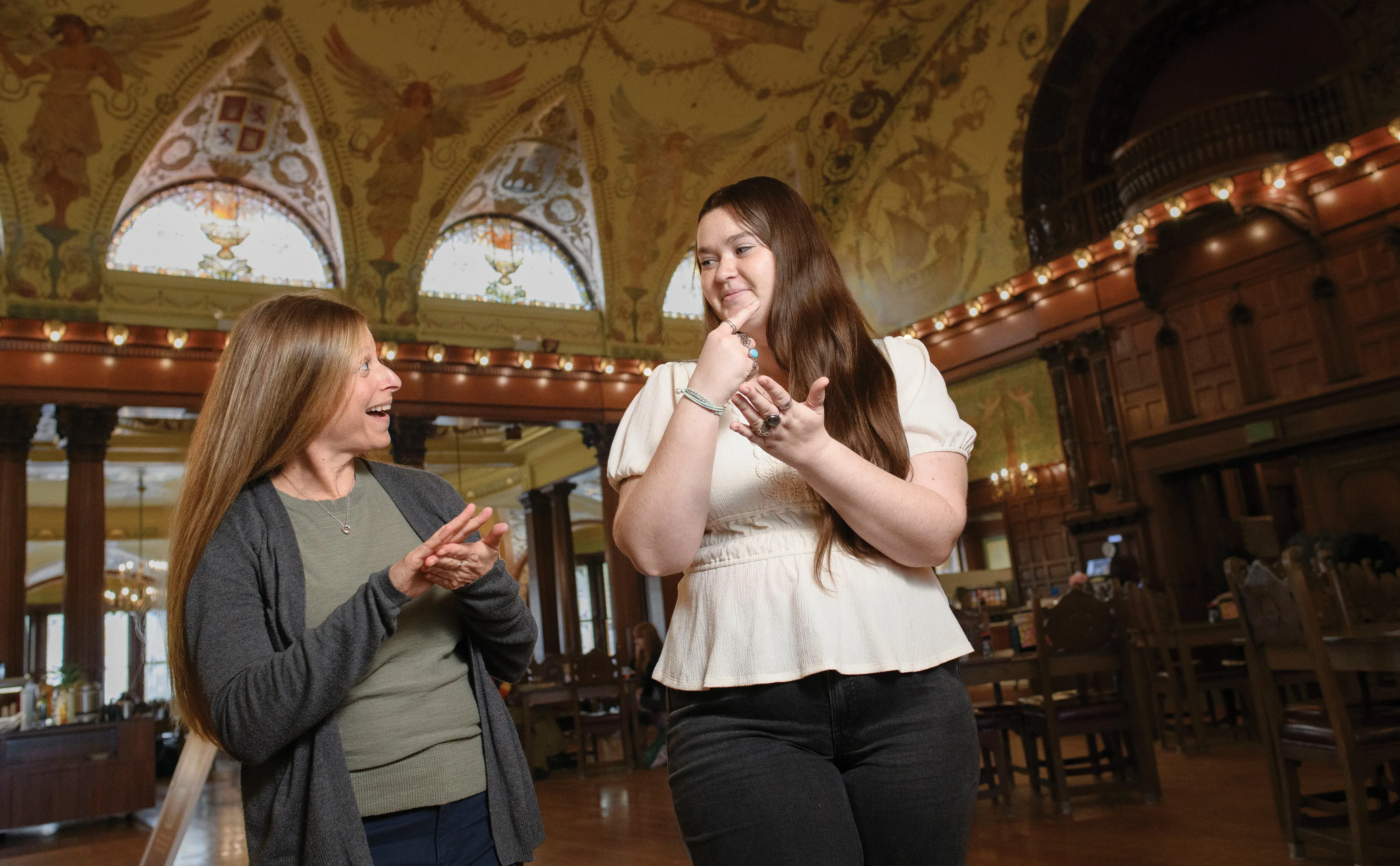 Assistant Professor Jennifer Catalano and Senior Allie Masterson are signing to each other in the Dining Hall