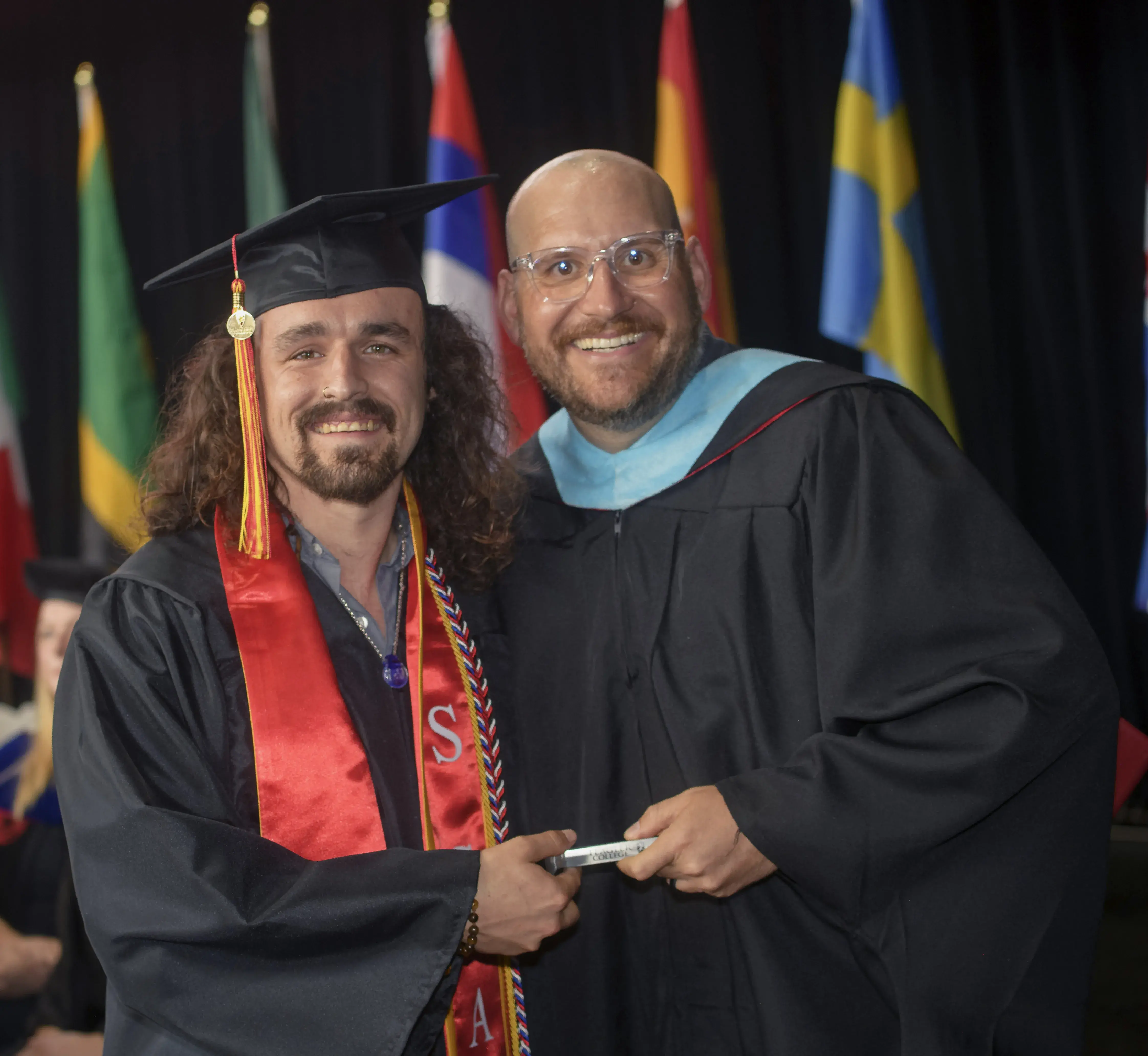 Jacob Harding handing out spikes at 2024 Commencement