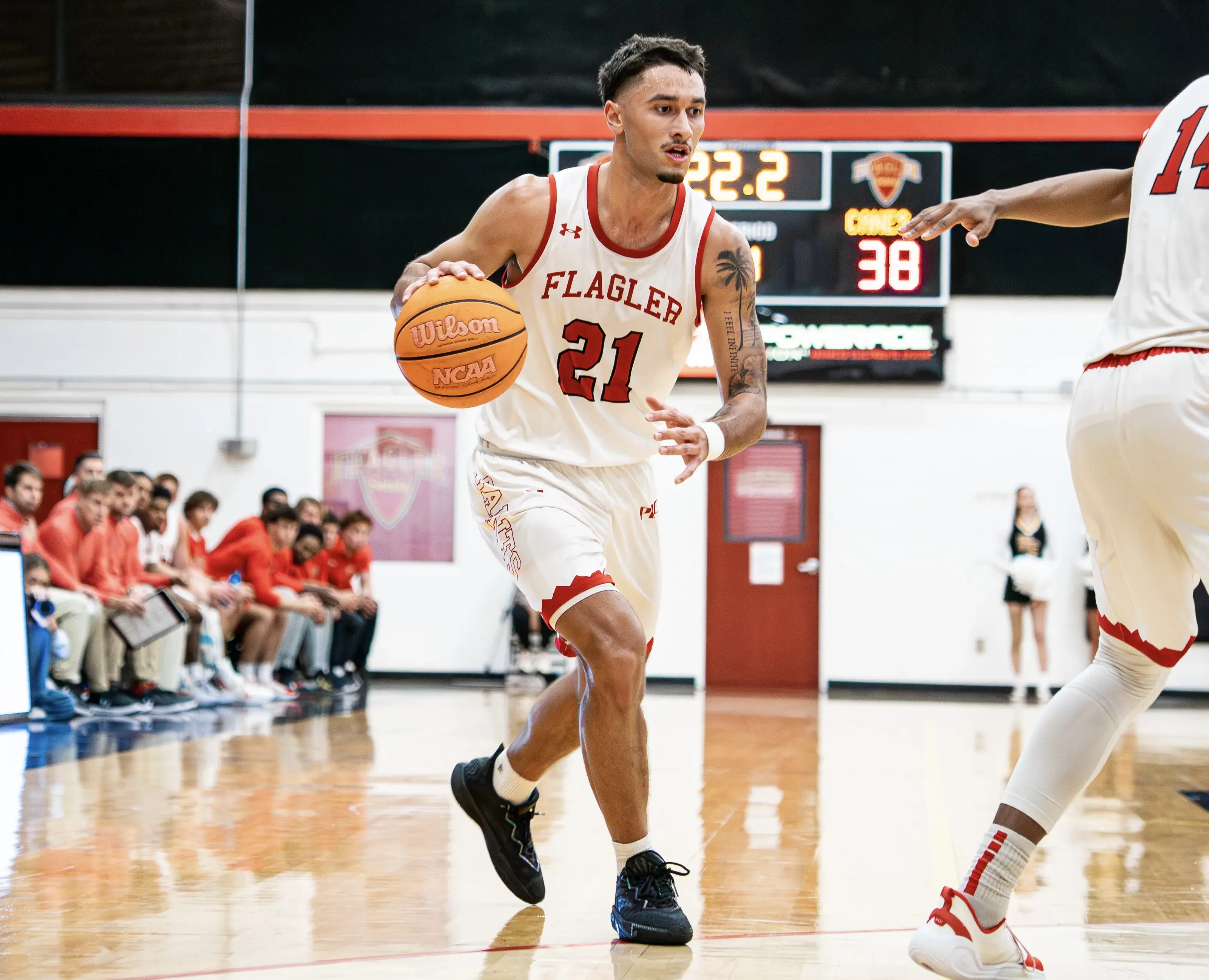 Hoku Fisher of Flagler Men's Basketball dribbles around his teammate's pick and heads towards the basket
