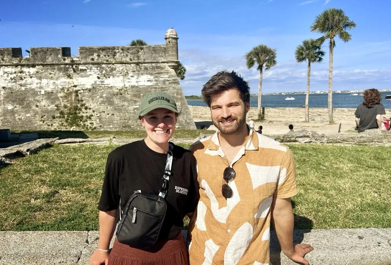 Shylowe Sortman and Florian Langer standing arm in arm with the Castillo de San Marcos behind them