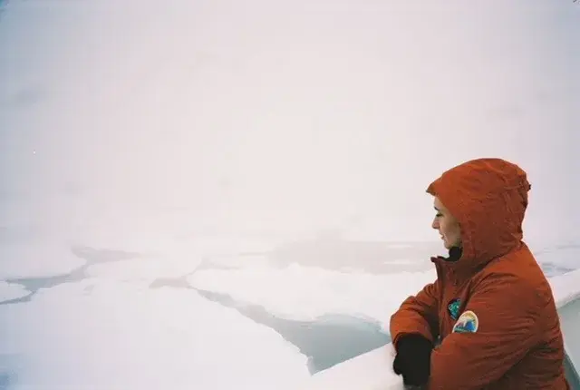 Alumni Claire Mortensen stares out at the Arctic Sea from a boat