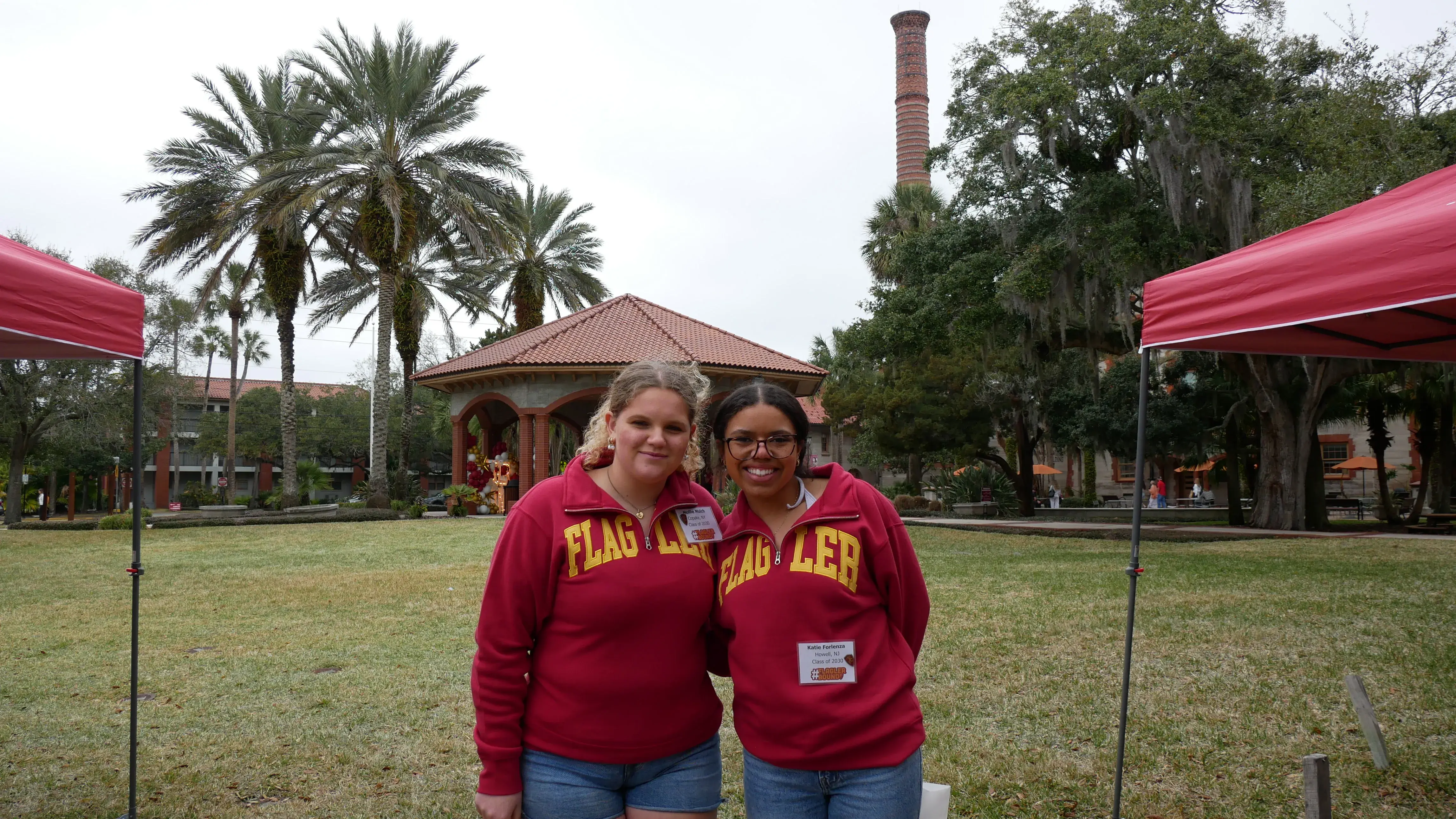 Two incoming Flagler students stand in red sweaters in fornt of Ponce De Leon Hall