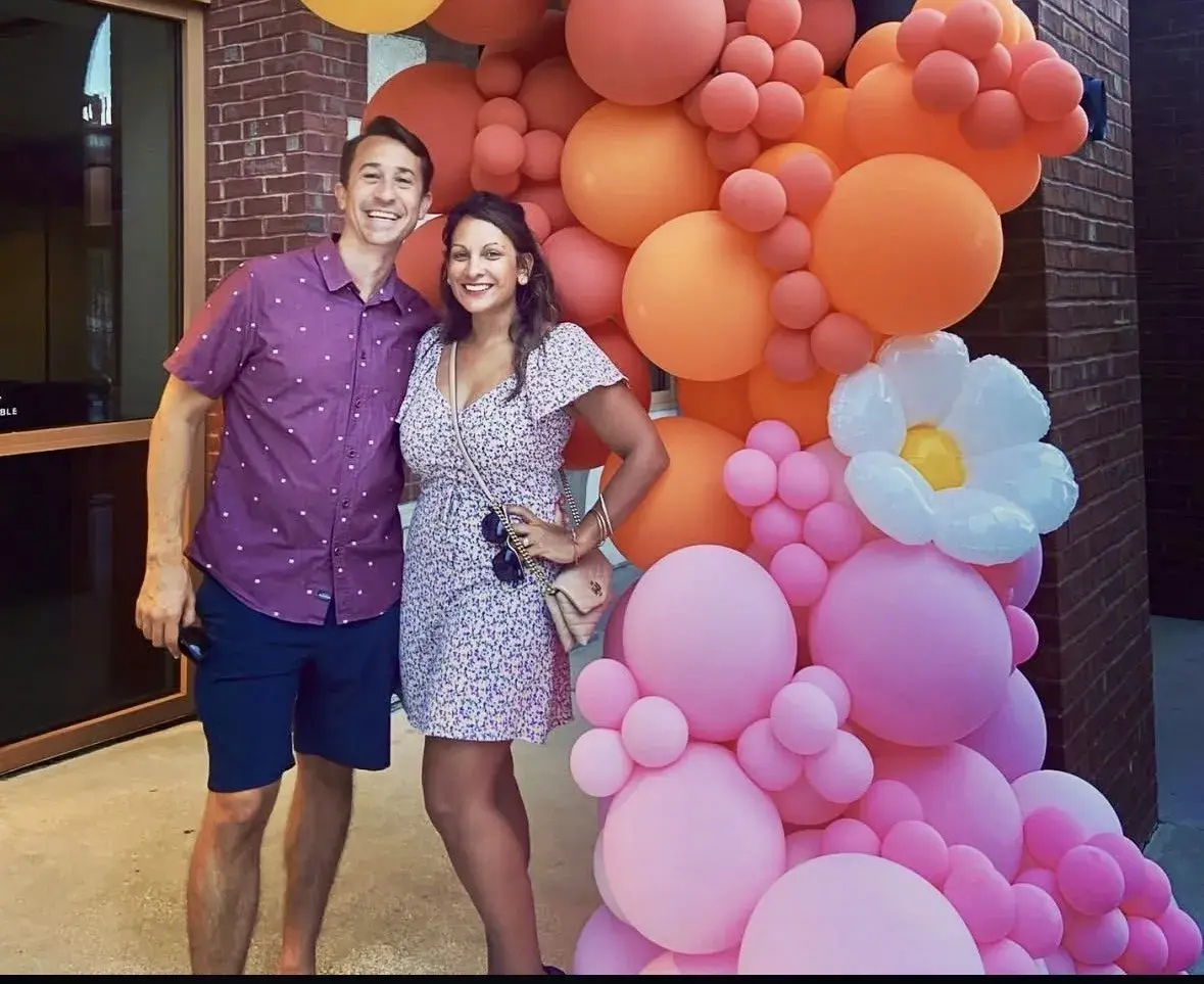 Emma and Drew Parmar stand near some balloons at a Flagler College event