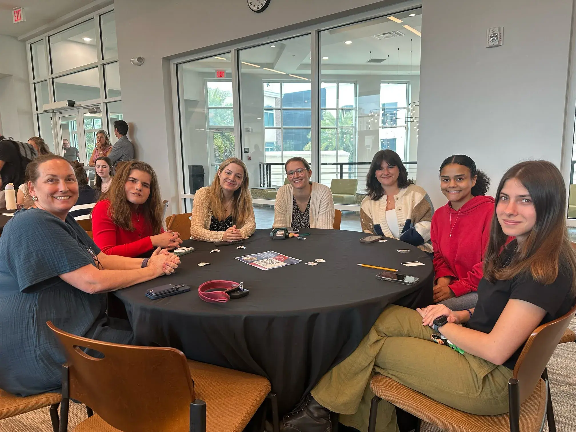 Students gather around a table prior to a dinner event during education week