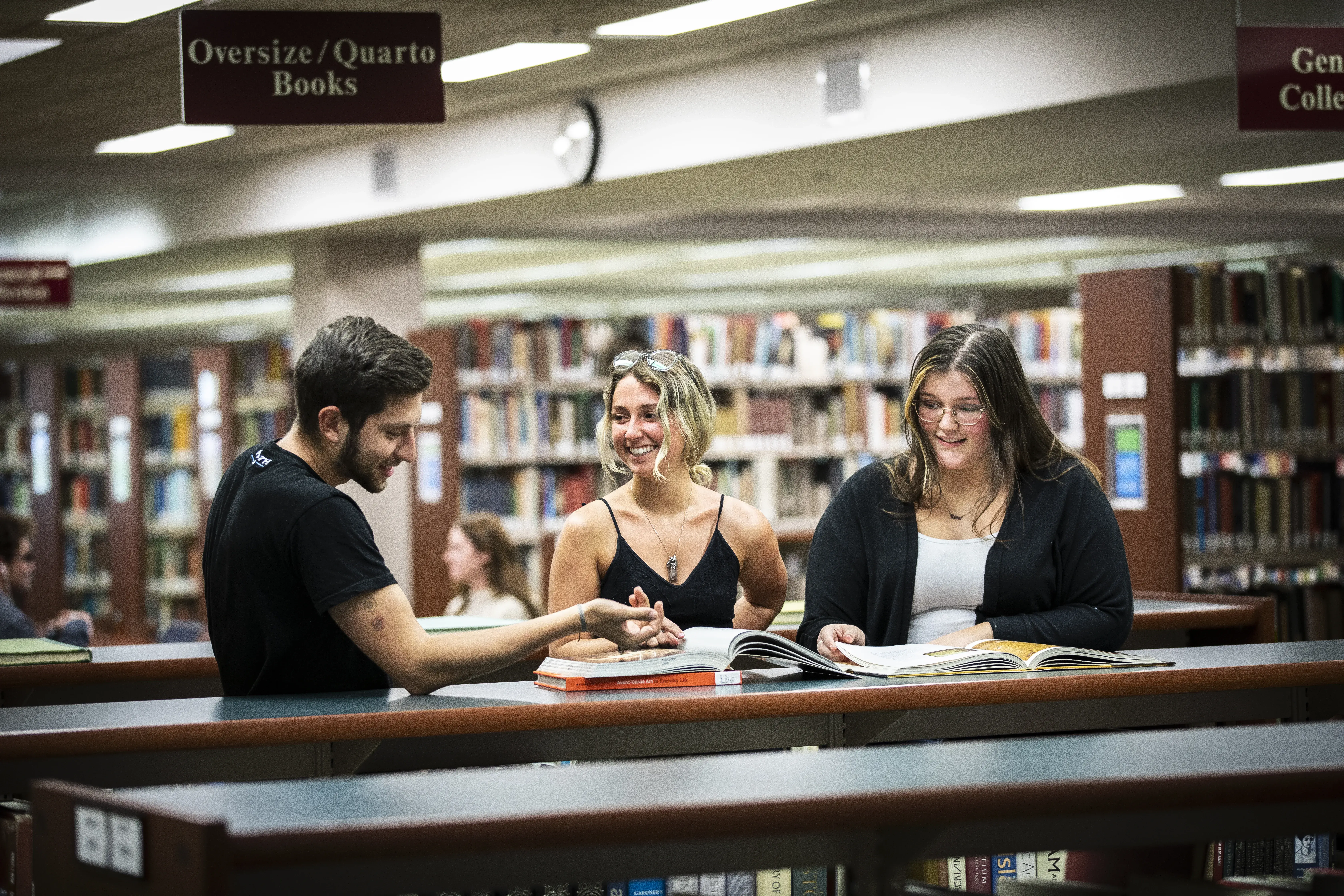 a photo of students talking with eachother inside of Proctor library