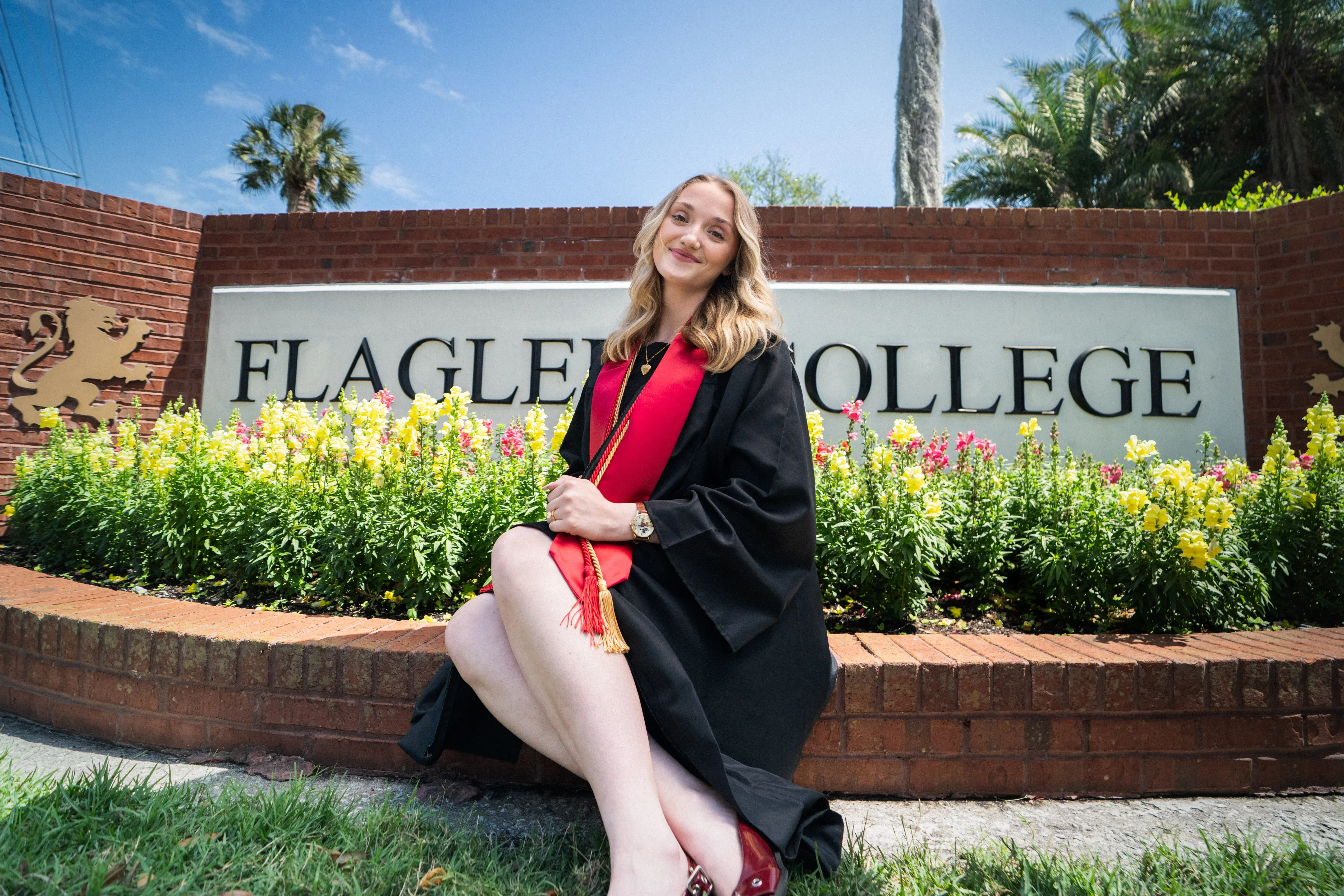 Zoey Nettles sits in front of a Flagler College entrance sign