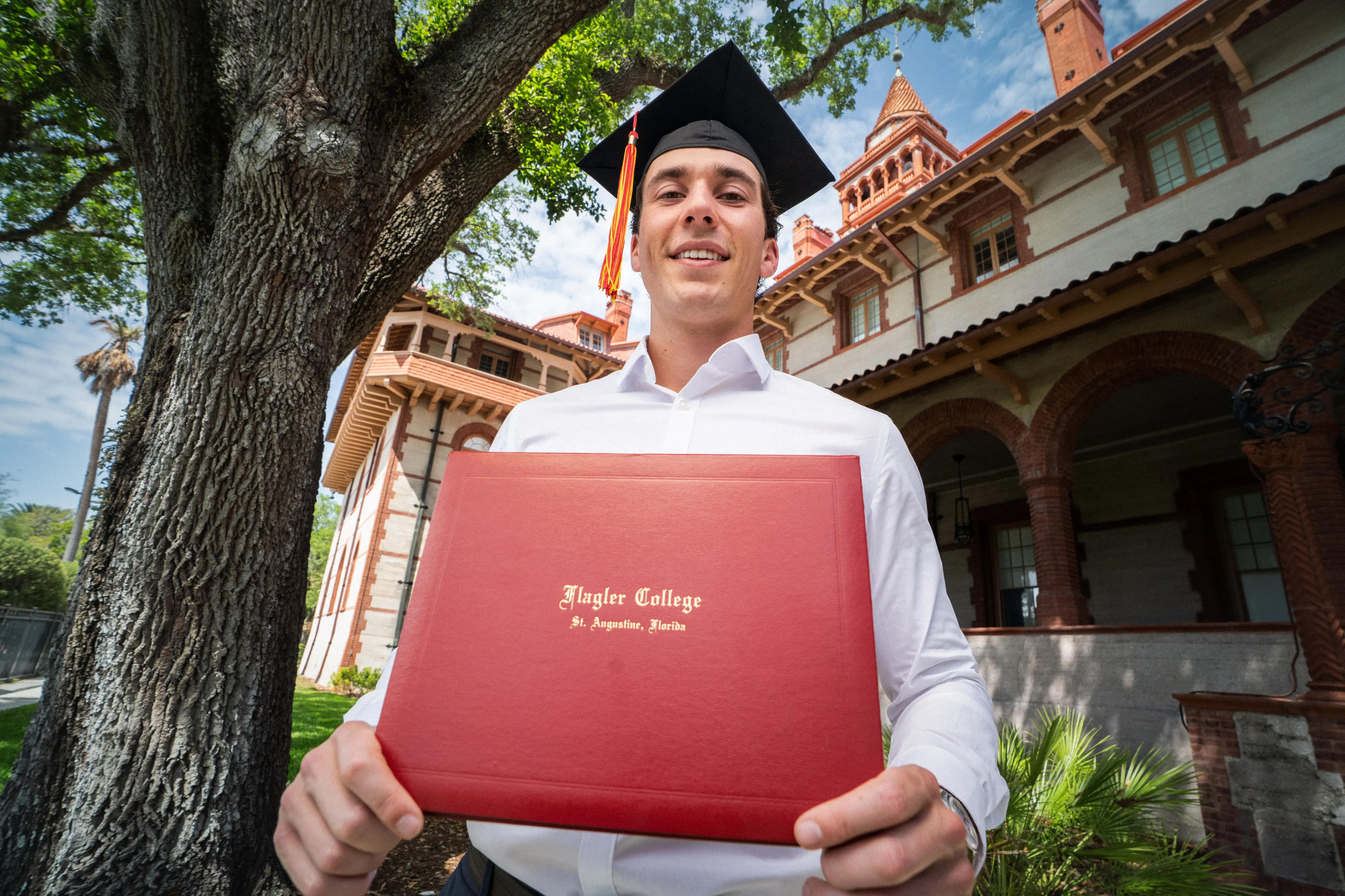 Jesse Van Krimpen holds out his diploma