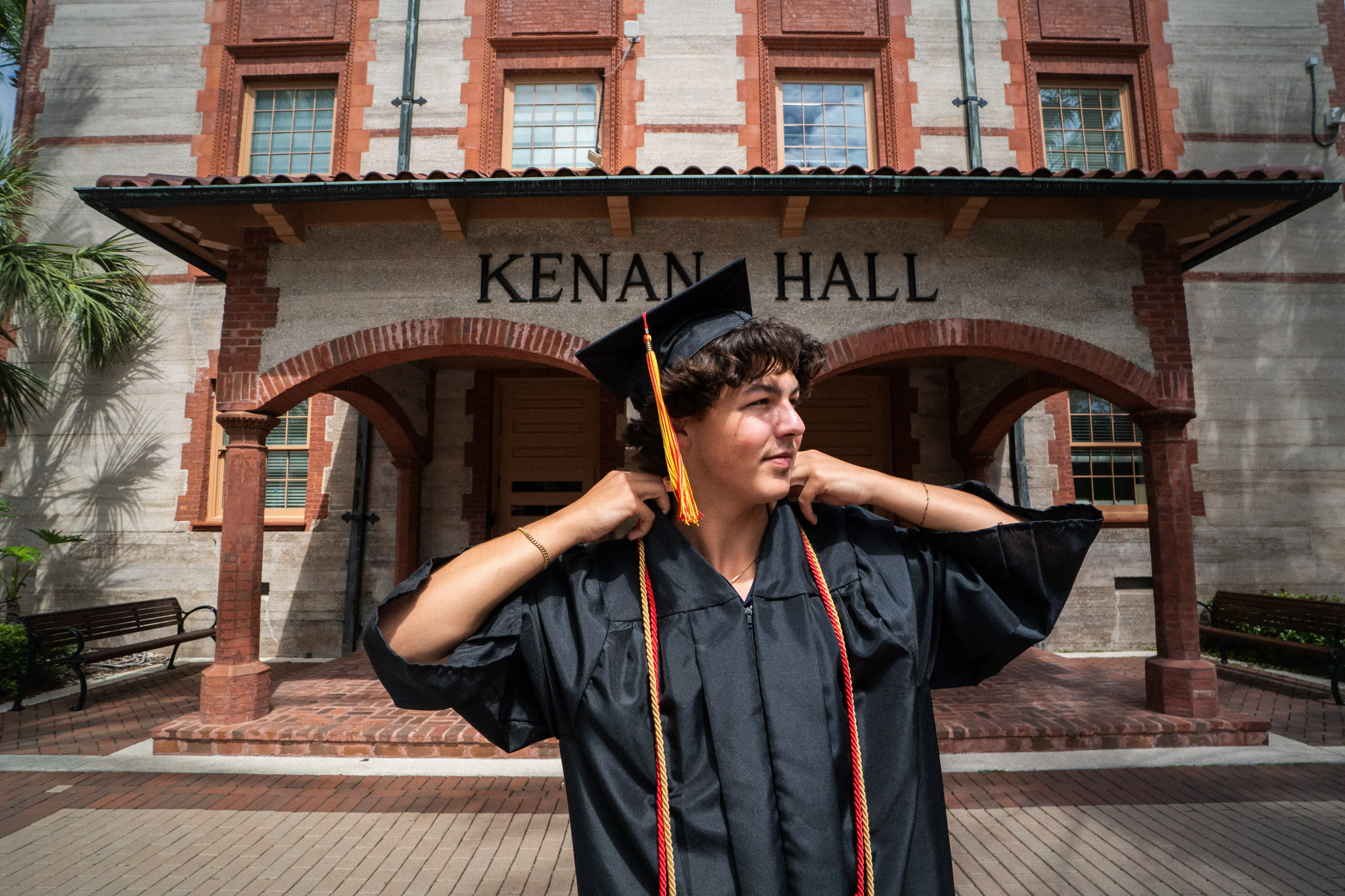 Randy Giglio fixes the collar of his grad gown
