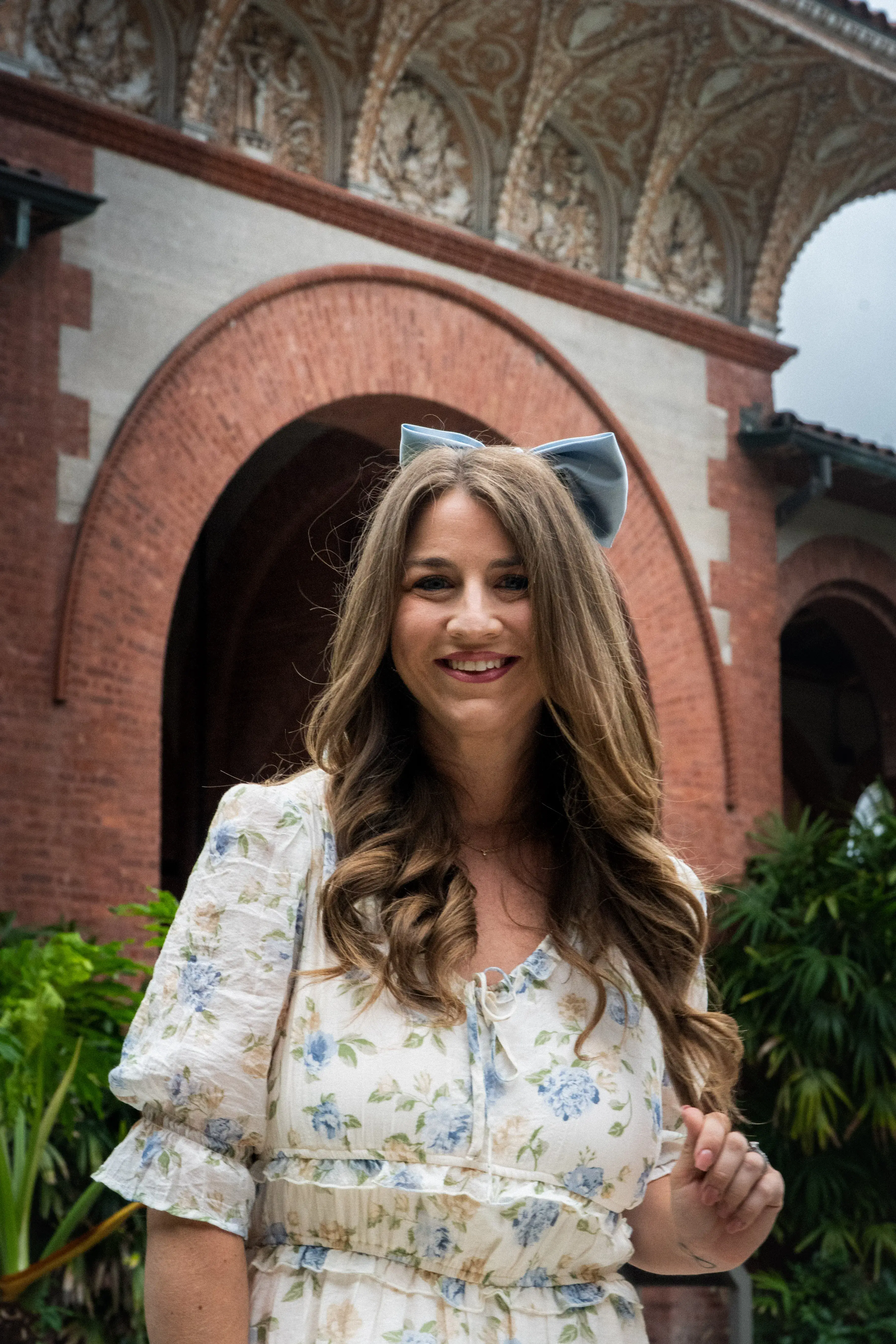 Rachel Wall posingf in front of the Flagler College front entrance gate