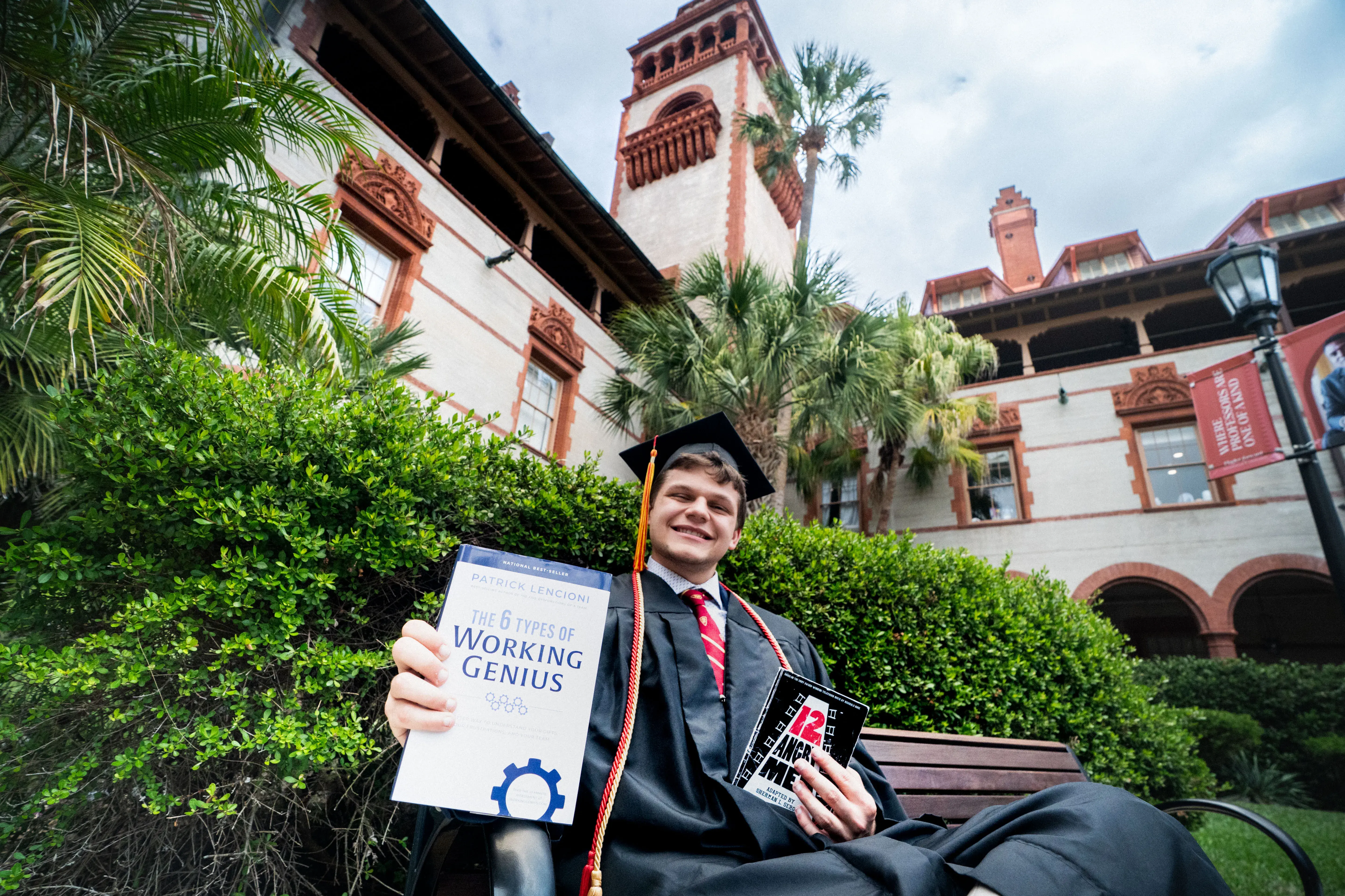 Tyler Newman with a couple books sitting outside The Ponce