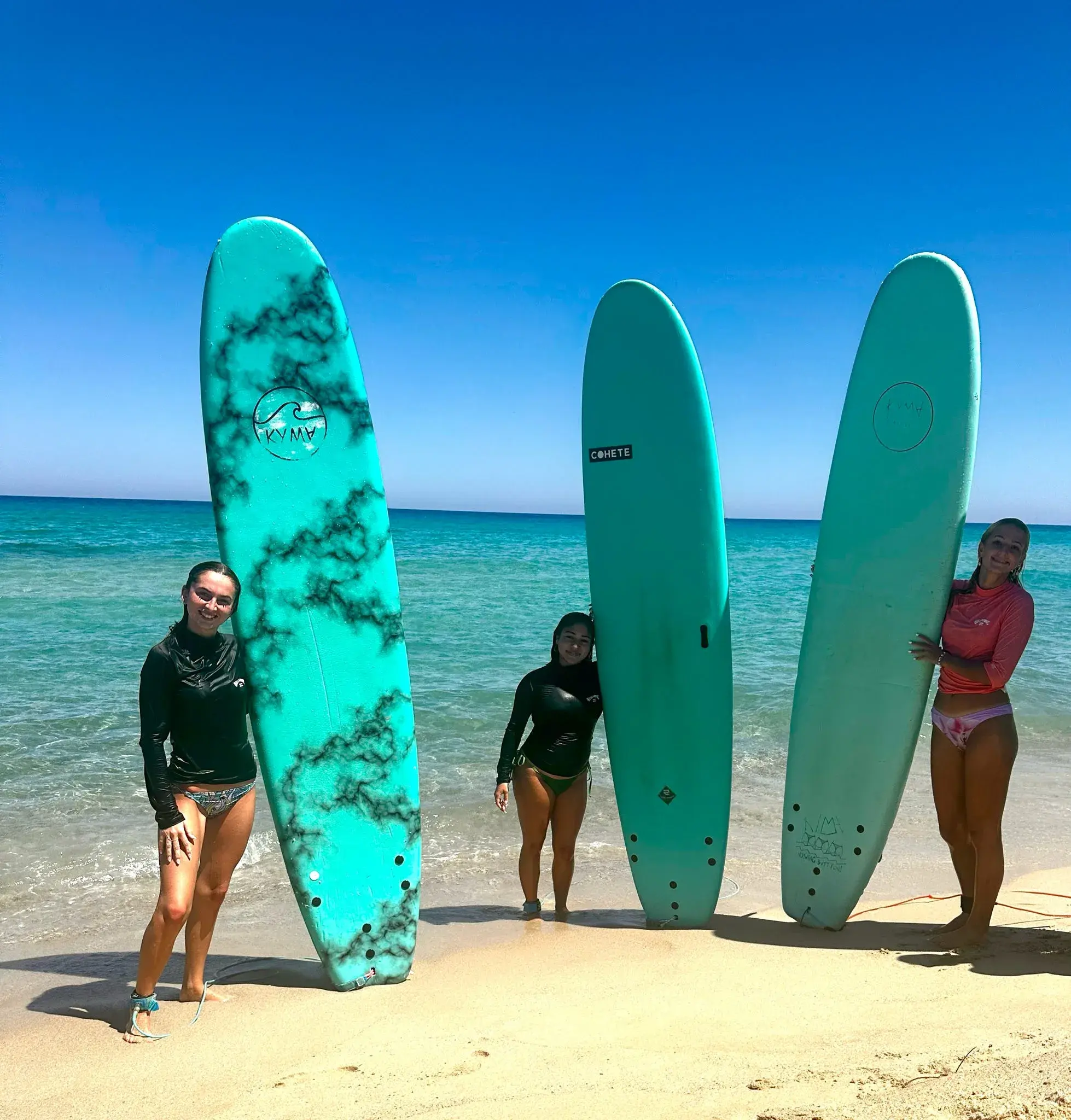Students pose with their surf boards on a surfing day in Ikaria