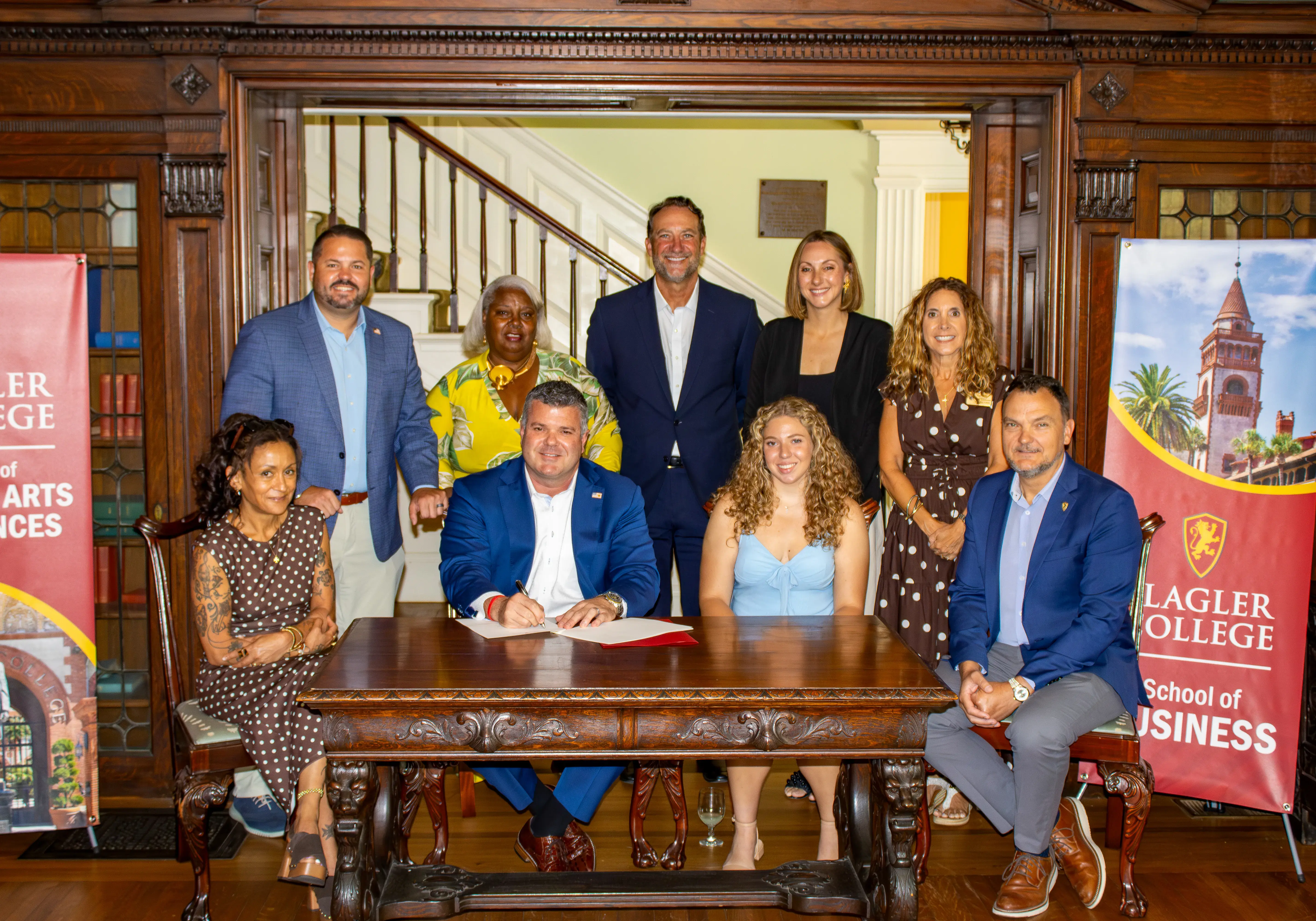 Scott Sturgill signs his gift to Flagler College with other local representatives around