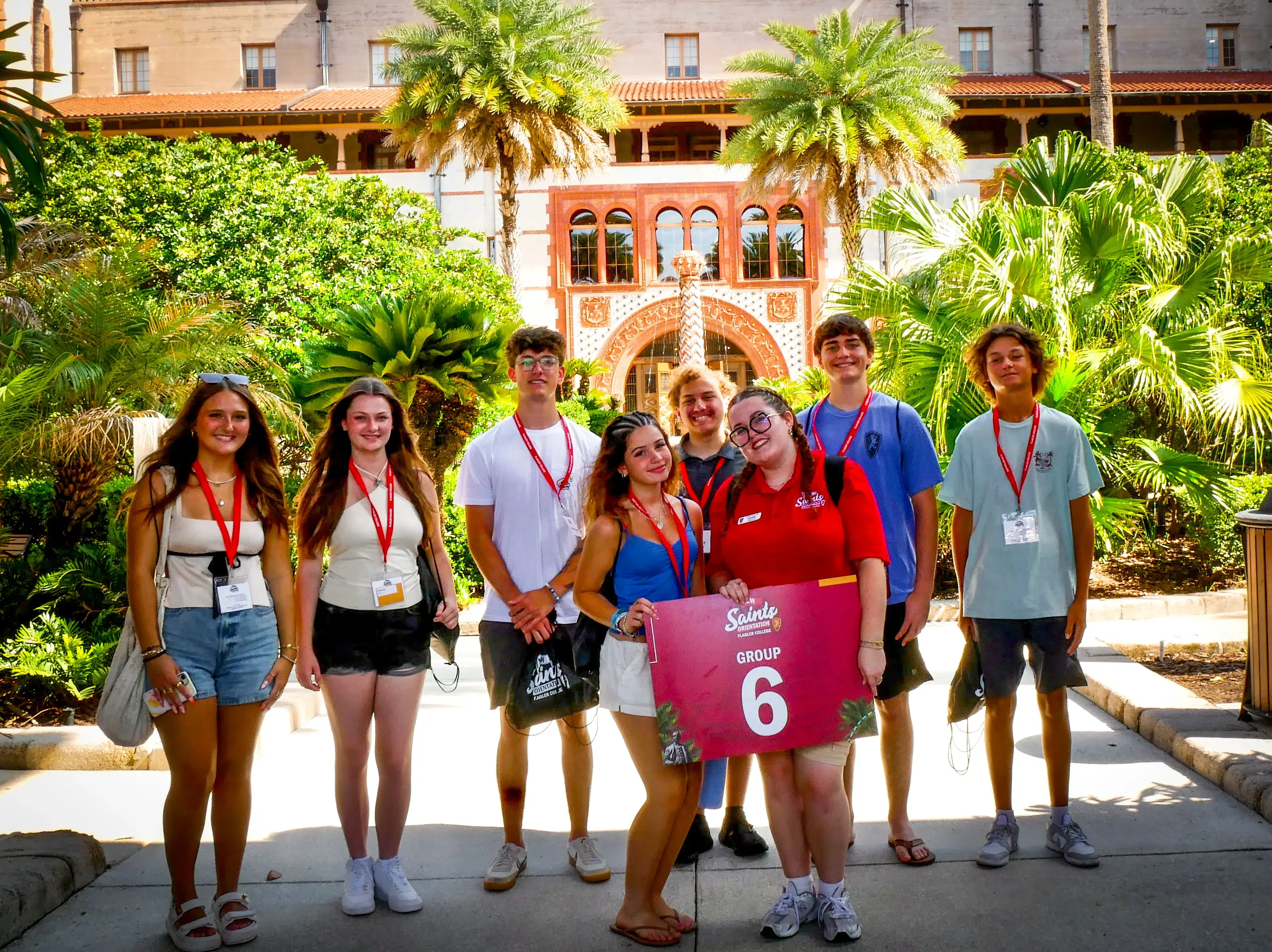 A group of orientation students and their leader stand underneath the Ponce entryway