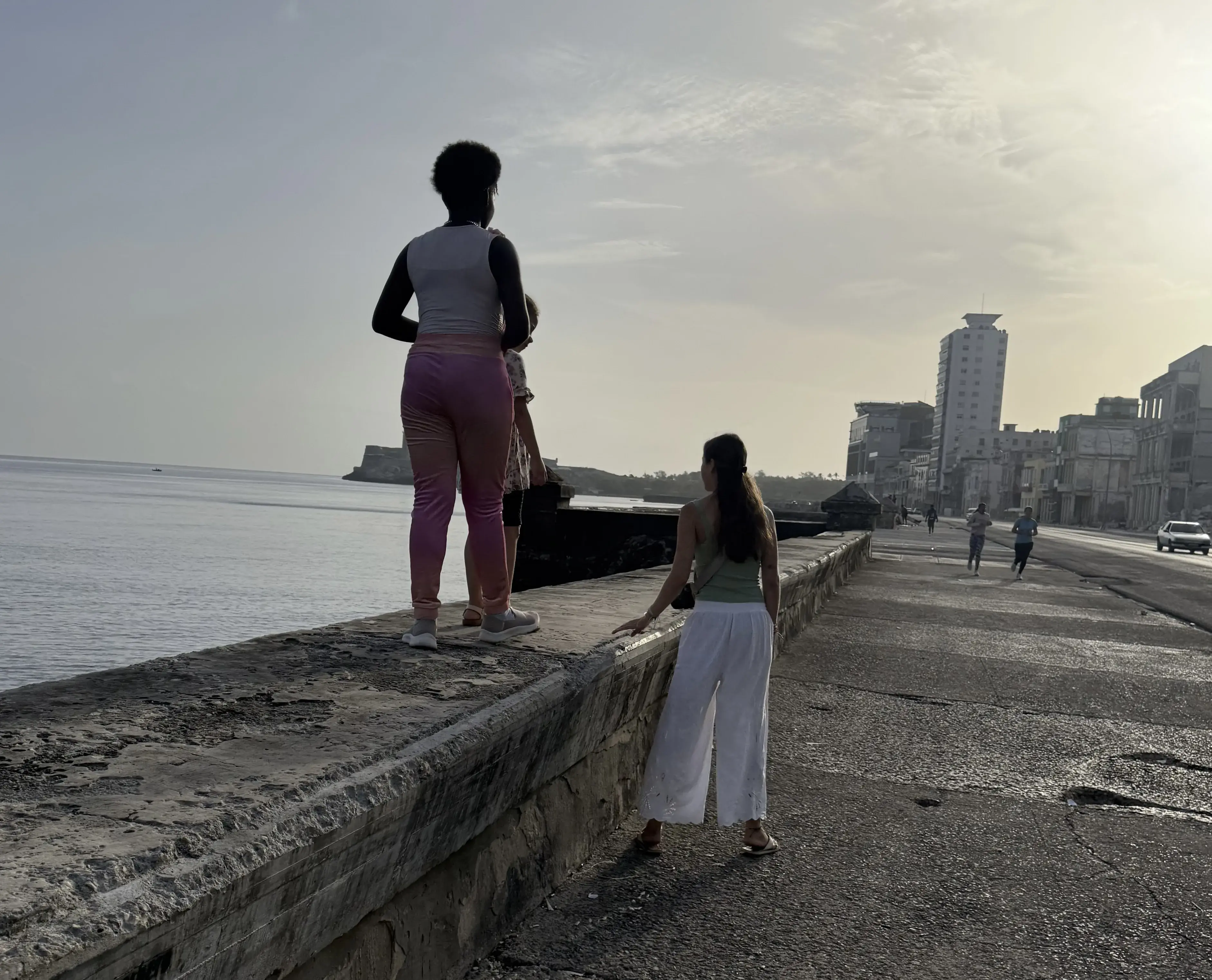 Sophia Cardona walking the shoreline in Cuba with a community member