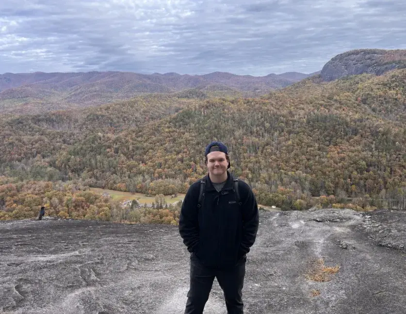 Aiden McGee stand with moountains behind him