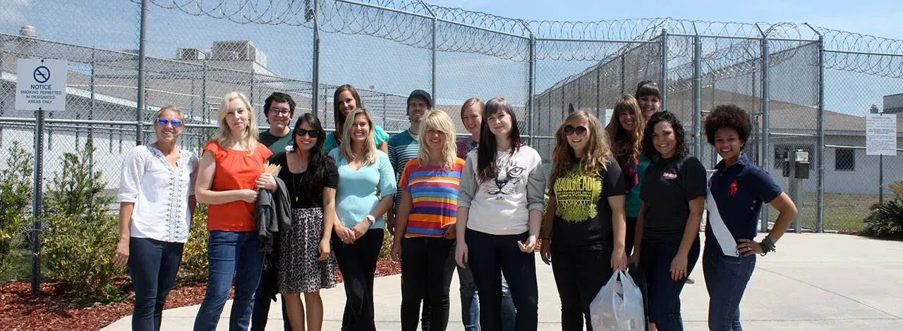 Image of students and art professor Leslee Robison working in the local prison with youth offenders. 