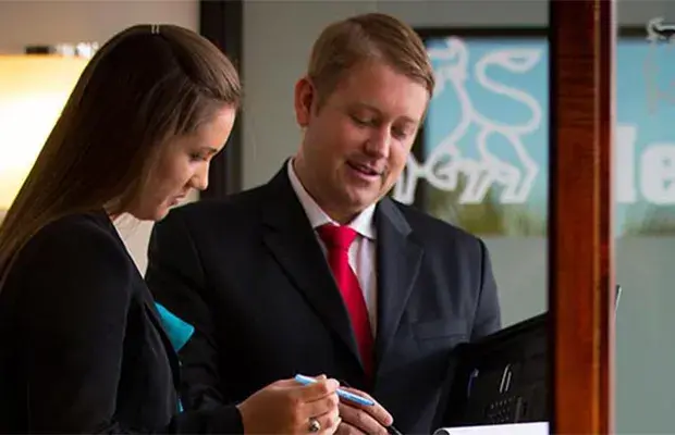 Business_Admin Hero.jpg Two businesspeople consult their notes together.